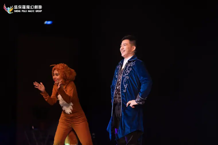新北市新莊文化藝術中心演藝廳《魔法師的考驗-地球危機!》 演出劇照:藍衣魔術師與獅子造型女演員同框
