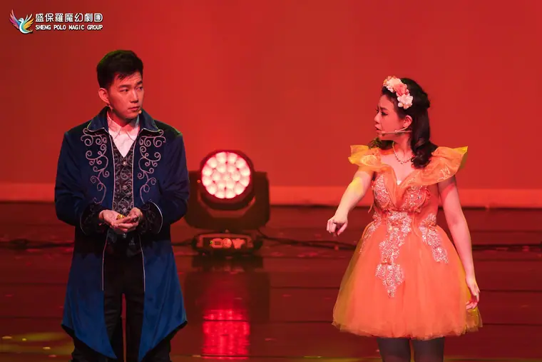 桃園展演中心展演廳《魔法師的考驗-地球危機!》 演出劇照:藍絨長袍男主與橘紗裙女主對戲