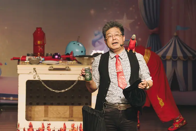 臺南市新化演藝廳《魔幻嘉年華》 演出劇照:魔術師在道具箱前抖開紅色絲巾