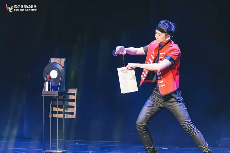 衛武營國家藝術文化中心《全明星魔術秀》 演出劇照:紅色軍裝魔術師大跨步倒酒入報紙