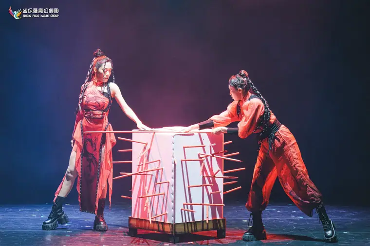 臺北表演藝術中心 球劇場《全明星魔術秀》 演出劇照:兩位紅衣女演員把長劍插滿白色穿刺箱
