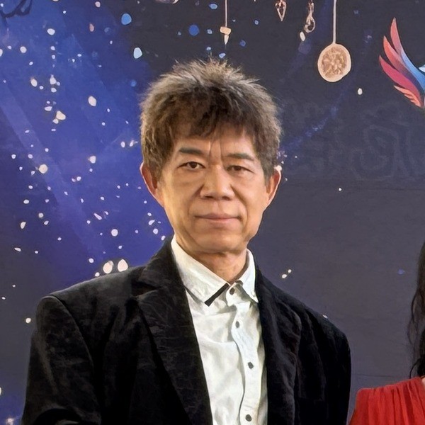 盛保羅魔幻劇團團長盛保羅,在豐村國小兒童節活動演出後於背板前留影