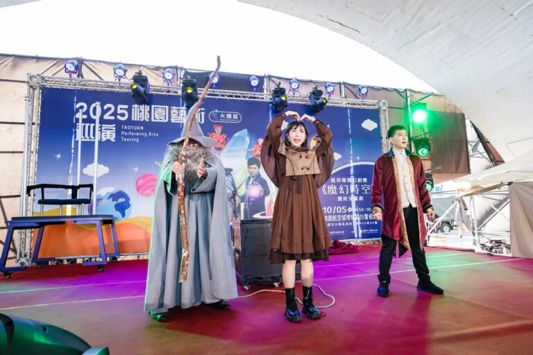 《魔幻時空》大園航空城戶外舞台,女主角在台上比愛心,旁邊是巫師和穿紅外套的角色