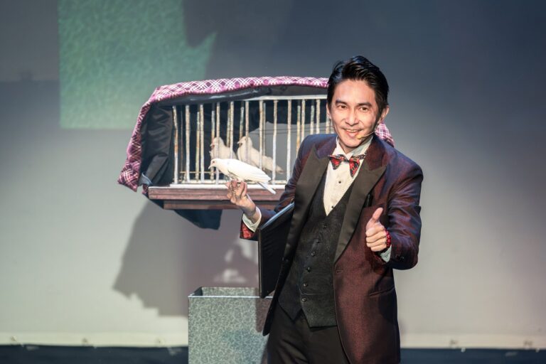 《魔法之夜》桃園市政府文化局演藝廳,魔術師幾米手捧白鴿,身後是鴿籠