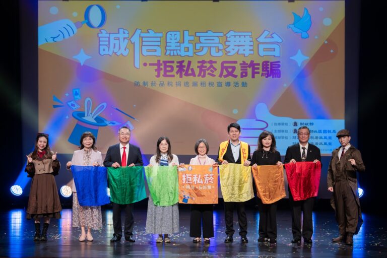 北區國稅局宣導活動舞台上,表演者與貴賓手持彩色布條合影