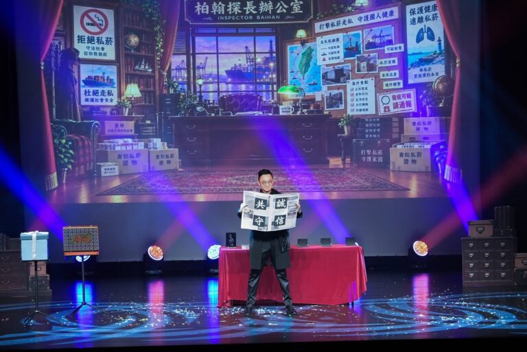 桃園市政府文化局演藝廳宣導活動拒私菸段落,魔術師在「柏翰探長辦公室」場景前攤開報紙