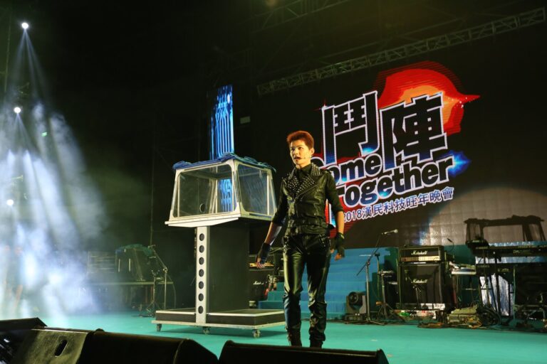 漢民科技旺年晚會大型魔術秀,魔術師在新竹縣體育館舞台的透明水箱道具旁表演
