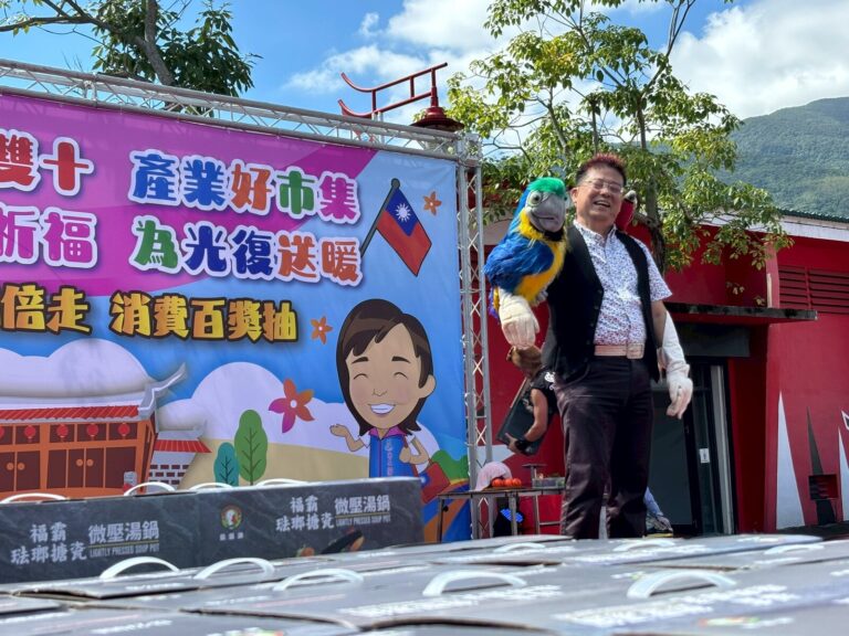 《兔兔的紅蘿蔔不見了！》花蓮吉安，腹語師與鸚鵡玩偶近景，背板寫著為光復送暖