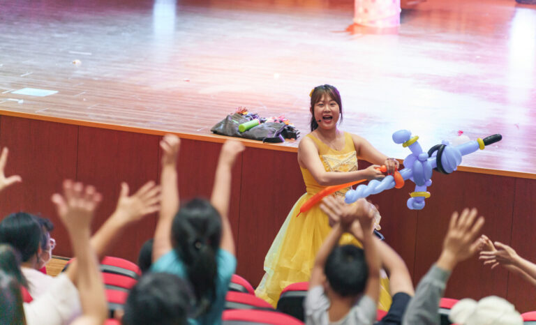 《魔幻嘉年華》臺南新化演藝廳,氣球天使拿著氣球作品,台下觀眾舉手