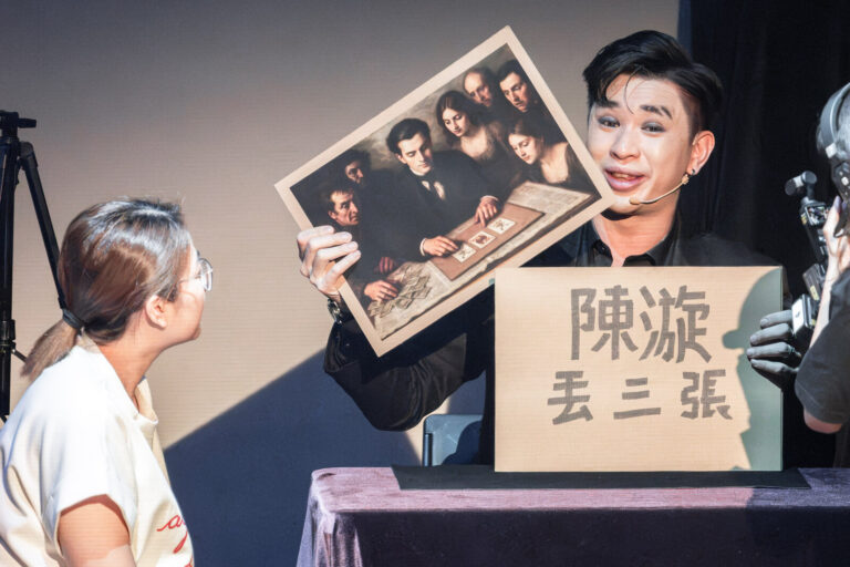 《魔法之夜》桃園市政府文化局演藝廳,魔術師陳漩與上台的觀眾對坐,亮出老照片與「陳漩 丟三張」字卡