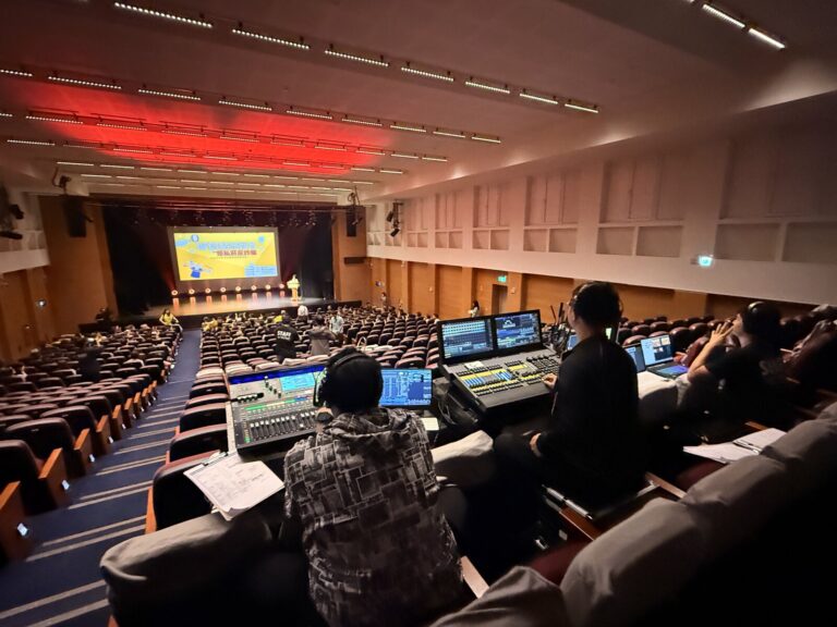 桃園市政府文化局演藝廳觀眾席中後段的導播與轉播控制區,前方舞台投影主視覺