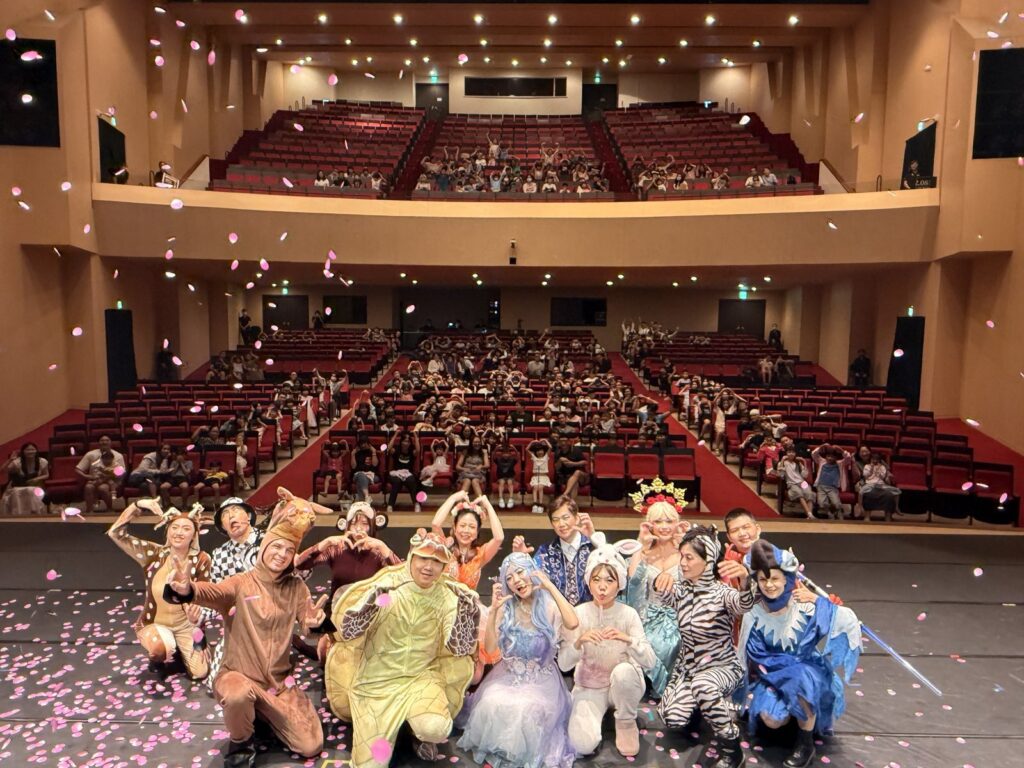 2026 新營藝術季《魔法師的考驗-地球危機!》新營文化中心謝幕,演員在舞台前合照,背後是觀眾席