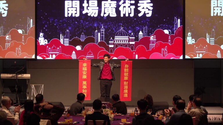 益華電腦 2024 尾牙開場魔術秀，魔術師拉出兩條寫著新年吉祥話的紅色直幅