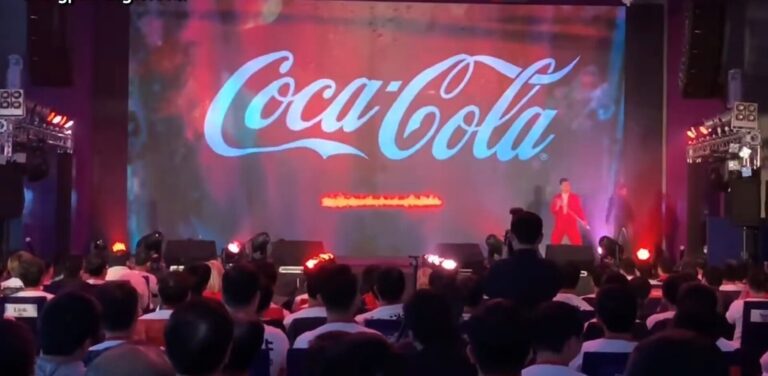 可口可樂 2019 產品發表會,投影打出 Coca-Cola 標誌,台下坐著來賓