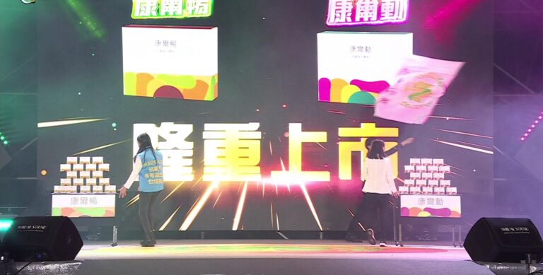 2024 企業產品發表會結尾,投影「隆重上市」,兩側桌上疊滿產品
