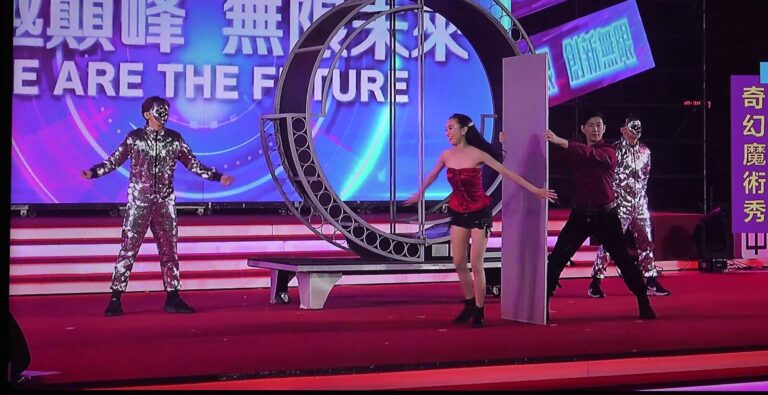 中保科技 2024 旺年會大型魔術秀,大圓環道具旁的紅衣女演出人員與銀色亮片裝舞者
