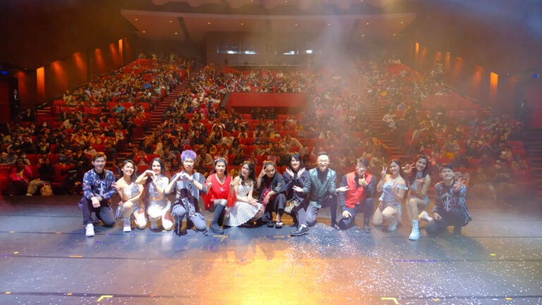 《全明星魔術秀》新北市藝文中心演藝廳謝幕,全體演出者蹲在台前,背後是一二樓觀眾席