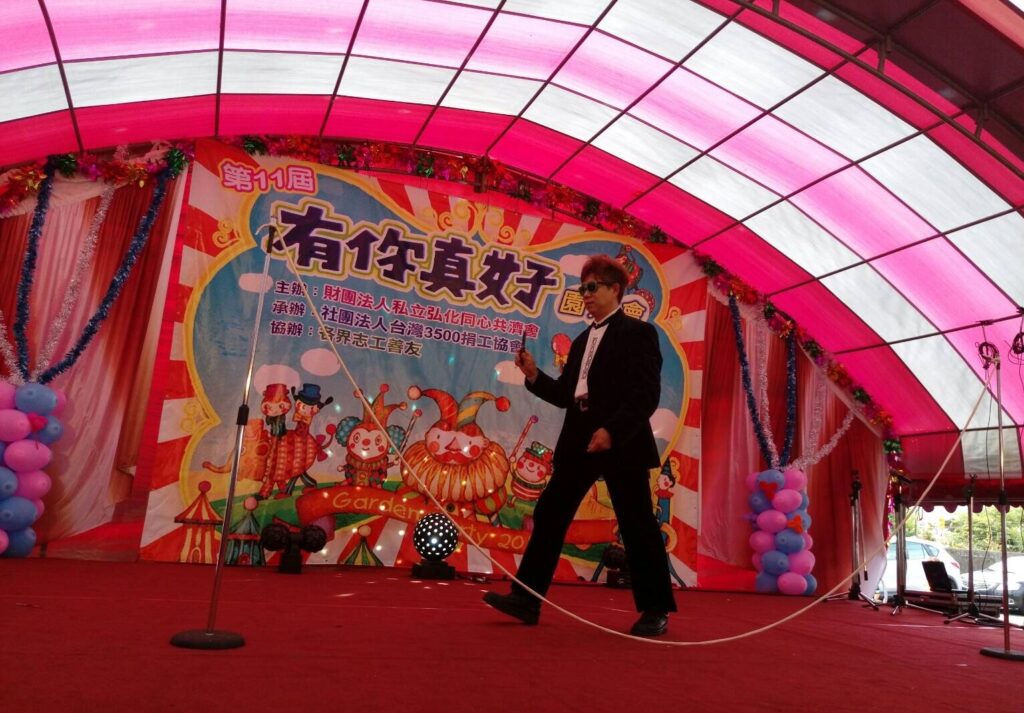 第 11 屆「有你真好」園遊會魔術表演，魔術師在背板前