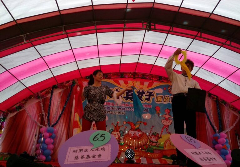 「有你真好」園遊會舞台魔術，表演者舉起圈環道具