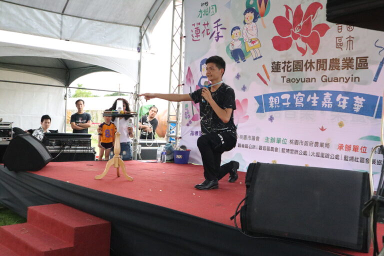 桃園蓮花季魔術秀，魔術師單膝跪地與上台小朋友互動