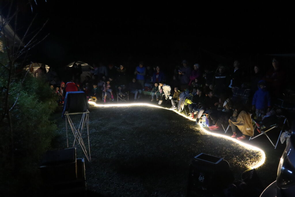 新竹雲起露營區夜間魔術秀，LED 燈條圍出表演區，露營客圍坐觀看