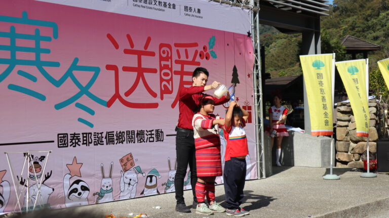 苗栗泰雅族部落國泰「寒冬送暖」耶誕偏鄉關懷活動,小朋友頭戴水桶的互動魔術