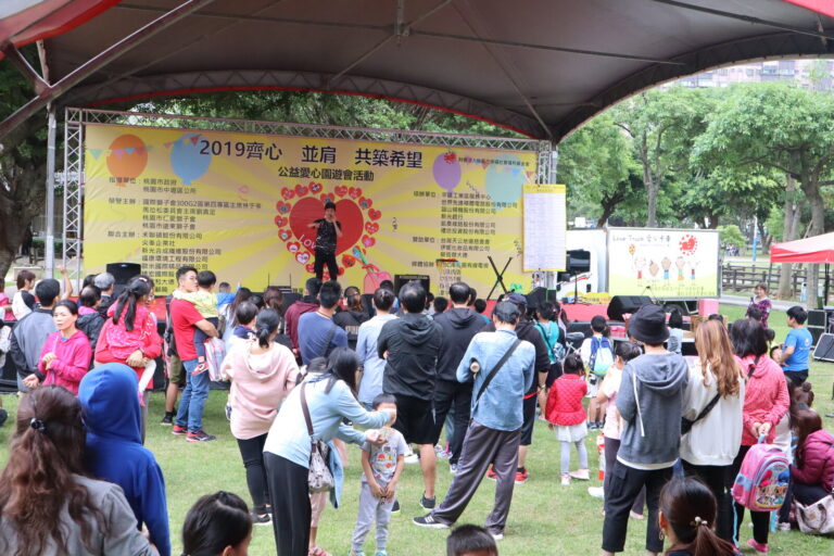 桃園中壢公益愛心園遊會魔術表演，舞台與草地人潮