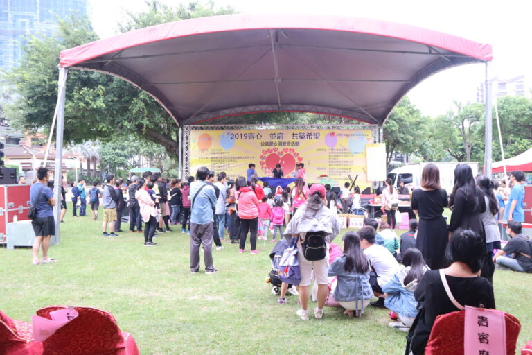 「2019齊心並肩共築希望」公益愛心園遊會魔術表演，草地會場人潮