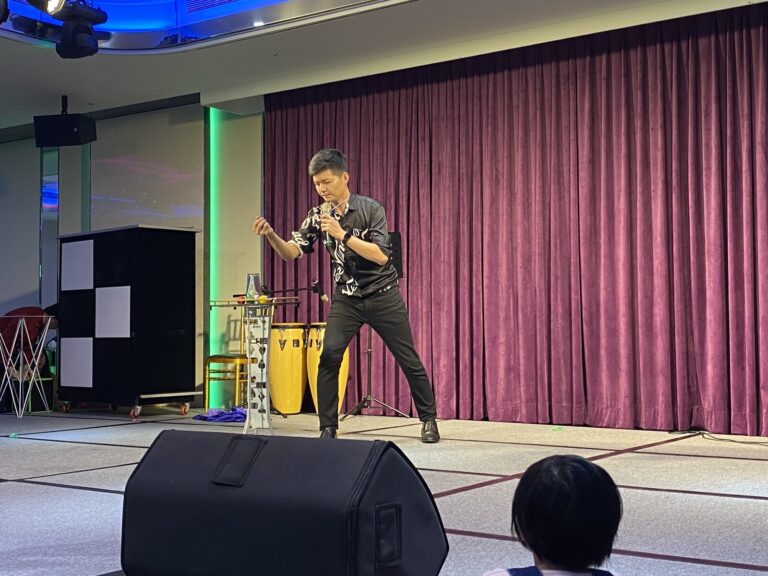 嘉義企業尾牙魔術表演,魔術師拿麥克風在台前