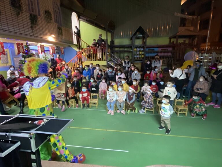 幼兒園聖誕晚會,小丑表演者與坐滿活動場的親子觀眾