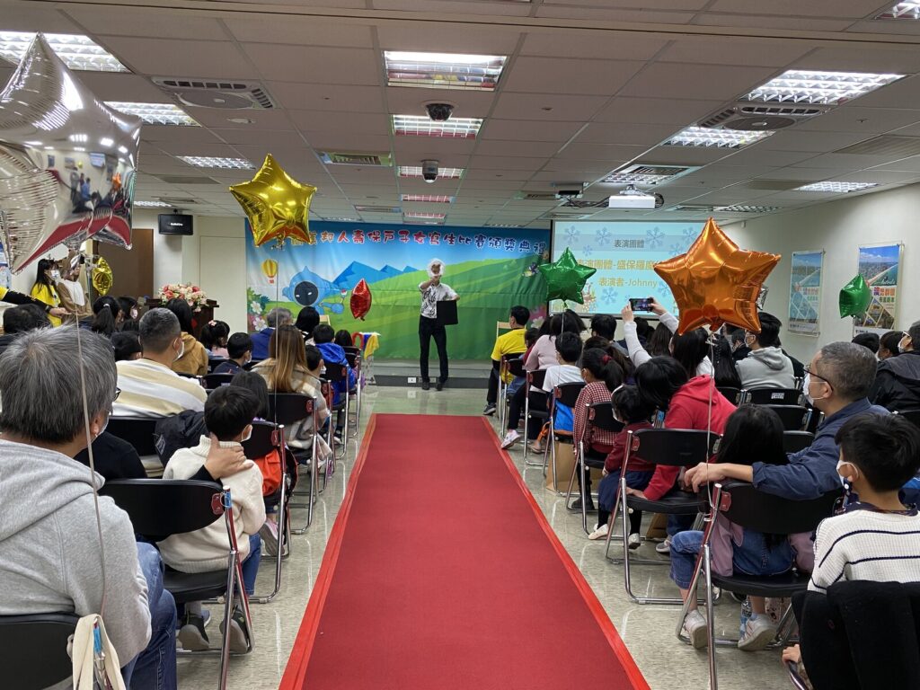 三商美邦人壽保戶子女寫生比賽頒獎典禮,從會場後方看魔術表演與兩側觀眾