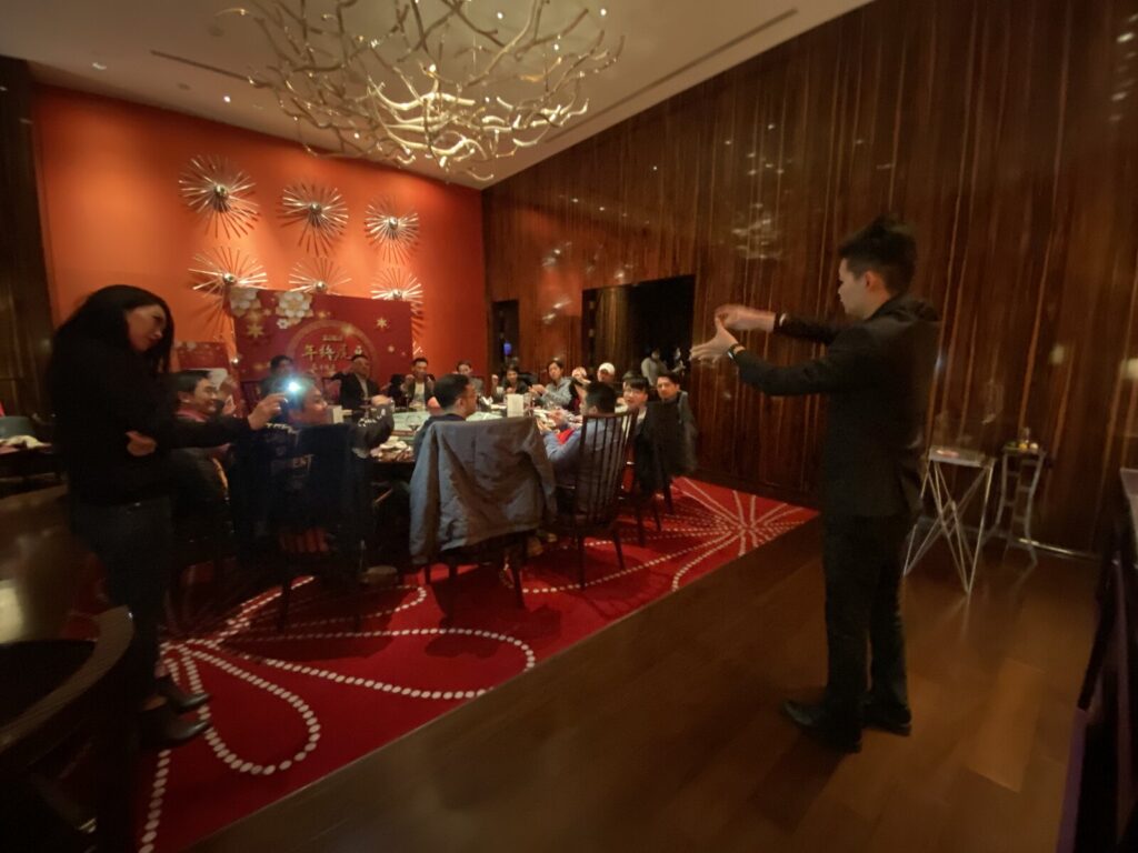 台北W飯店企業尾牙魔術表演，魔術師在宴會包廂中表演，賓客圍桌