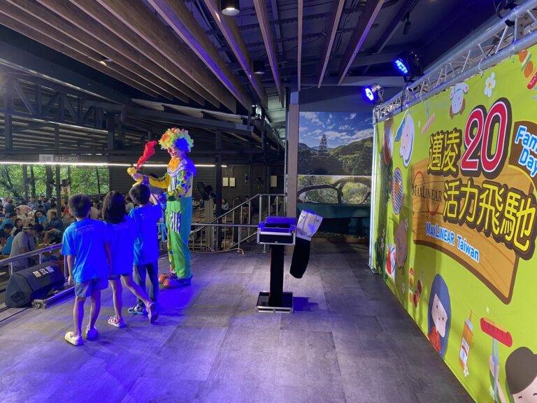 小丑在紫色燈光舞台上帶小朋友互動，大板根家庭日