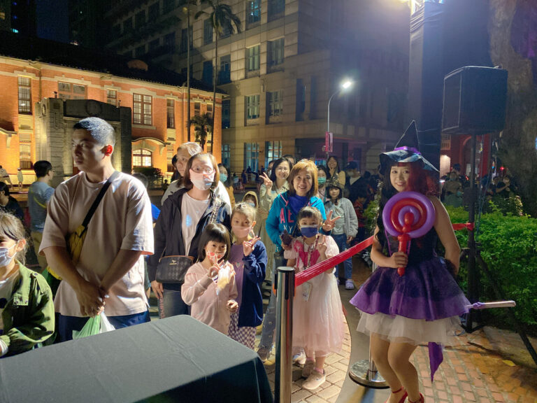 新竹萬聖節排隊等造型氣球的民眾與女巫表演者