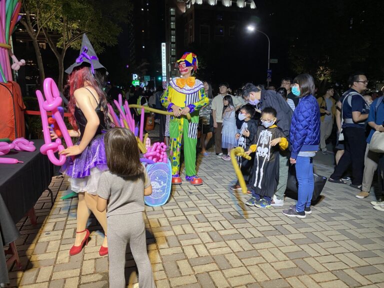 新竹萬聖節現場,小丑與女巫在攤位前和民眾互動