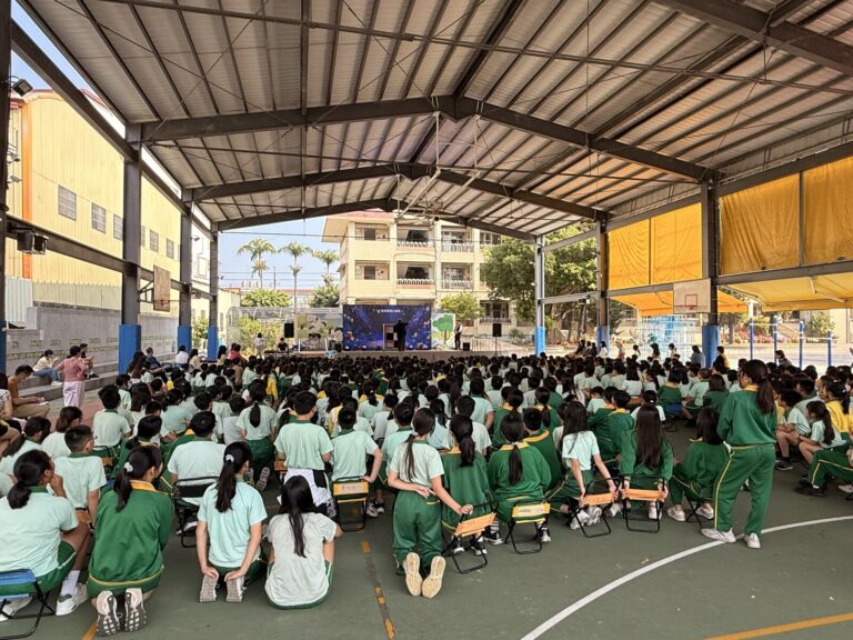 豐村國小風雨操場坐滿學生，從學生後方看向兒童節魔術演出舞台