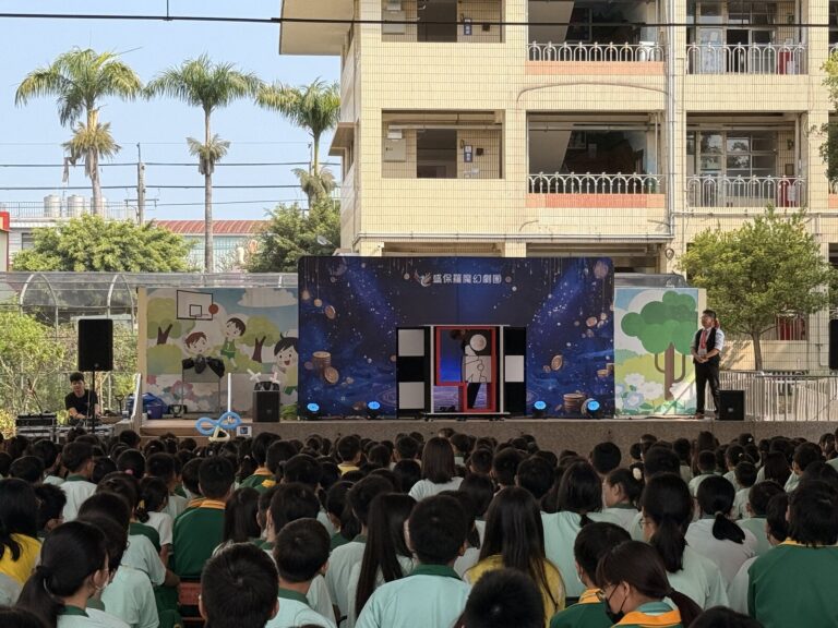 豐村國小兒童節魔術演出舞台遠景，台下學生背影
