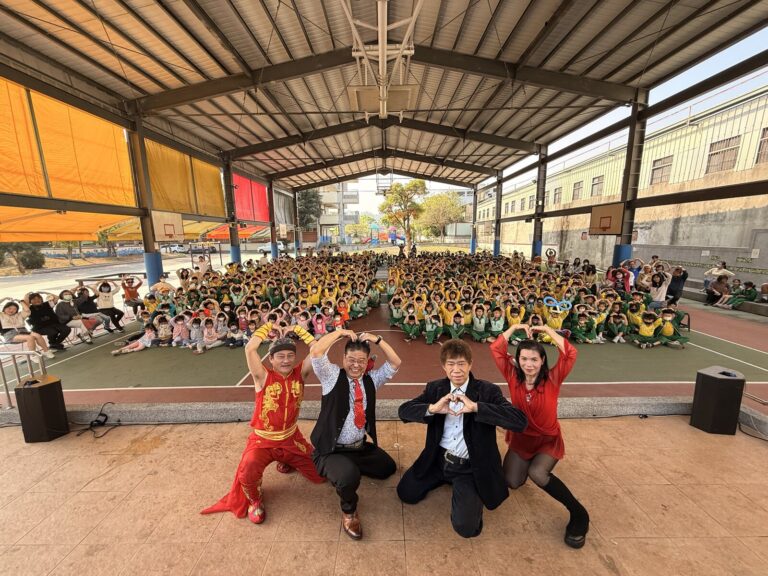 兒童節演出人員比愛心，後方是豐村國小全校學生