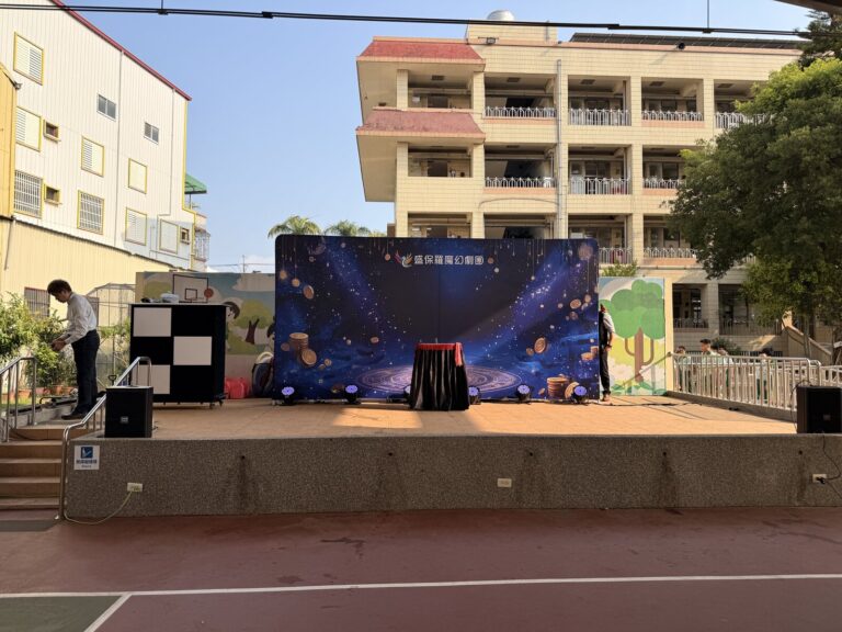 豐村國小兒童節演出前的舞台與盛保羅魔幻劇團背板