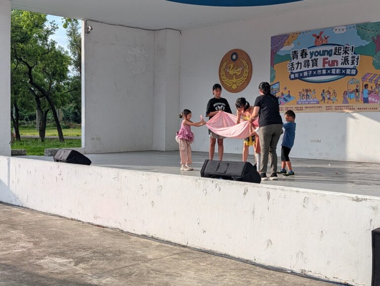 小朋友上台和表演者一起拉開彩色布巾，虎頭山創新園區「青春 young 起來」魔術演出
