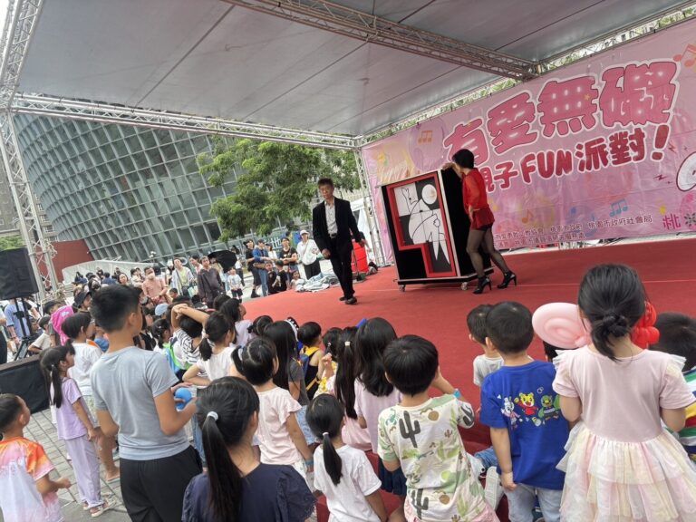桃園藝文廣場「有愛無礙親子 FUN 派對」魔術演出，小朋友在台前觀看的背影