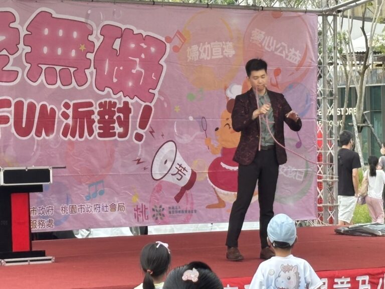 魔術師在桃園藝文廣場「有愛無礙親子 FUN 派對」背板前表演