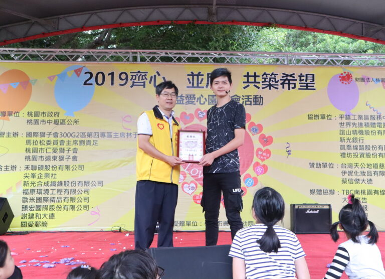 「2019齊心並肩共築希望」公益愛心園遊會，魔術師在舞台上接受感謝狀